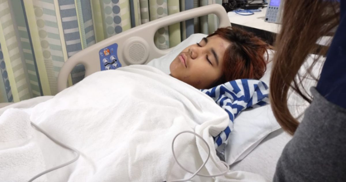 An injured Aiden lays in a hospital bed.