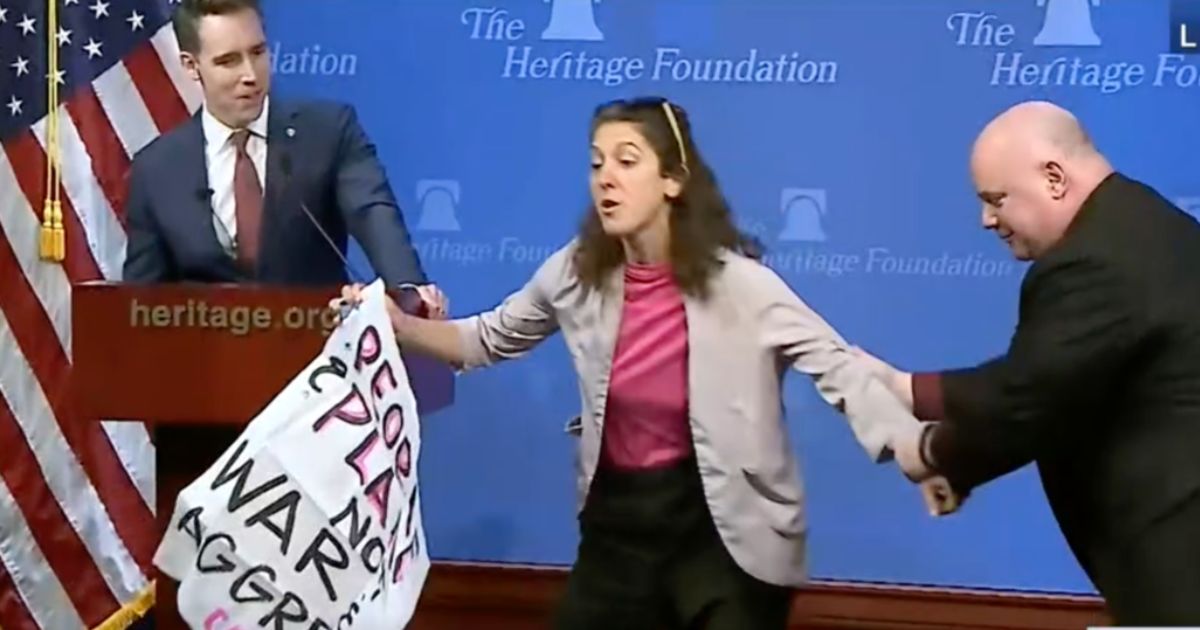 During Sen. Josh Hawley's speech on Thursday, he was interrupted by a climate activist, who had to be pulled off the stage.
