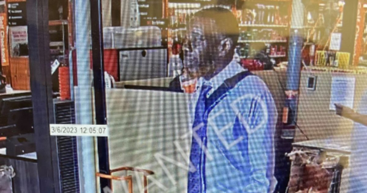 Via video surveillance, one of two males suspected of scamming an elderly man in Louisiana is shown walking.