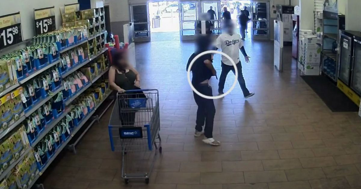 This YouTube screen shot of Walmart surveillance footage shows a police officer and loss prevention employee confronting a suspected shoplifter with a gun.