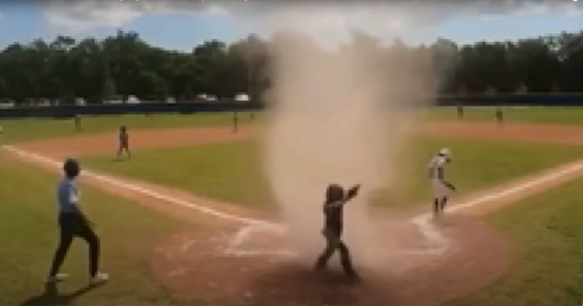 The whirlwind engulfed the 7-year-old catcher at home plate.