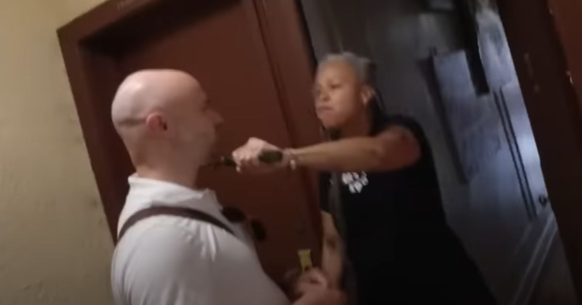Shellyne Rodriguez, a professor at Hunter College in New York, holds a machete against the neck of a New York Post reporter.