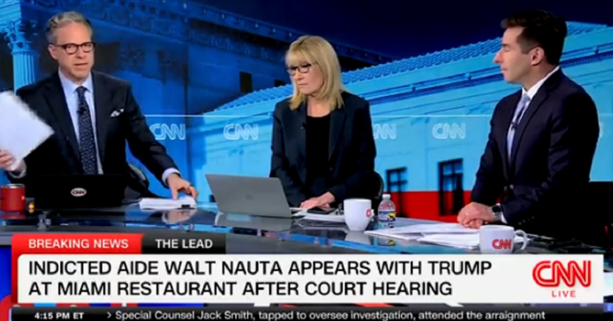 CNN's Jake Tapper waves his notes on the set of "The Lead with Jake Tapper" on Tuesday as he ends live coverage of former President Donald Trump among supporters at a Miami restaurant.