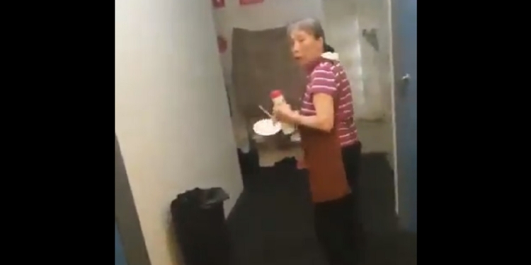 A hostel maid looks back at a camera as a man claiming to be a "trans woman" followers her.