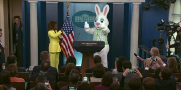 White House press secretary Karine Jean-Pierre with a character in a rabbit suit at the press room podium on Monday.