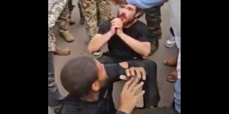 Two man sit on the ground surrounded by Congolese soldiers after a coup attempt Sunday in Kinshasa, the capital of the Democratic Republic of Congo.